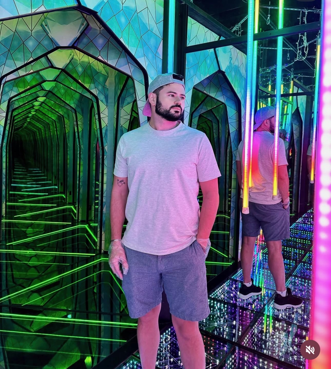 Adrecal standing in a mirrored corridor lit by neon tubes